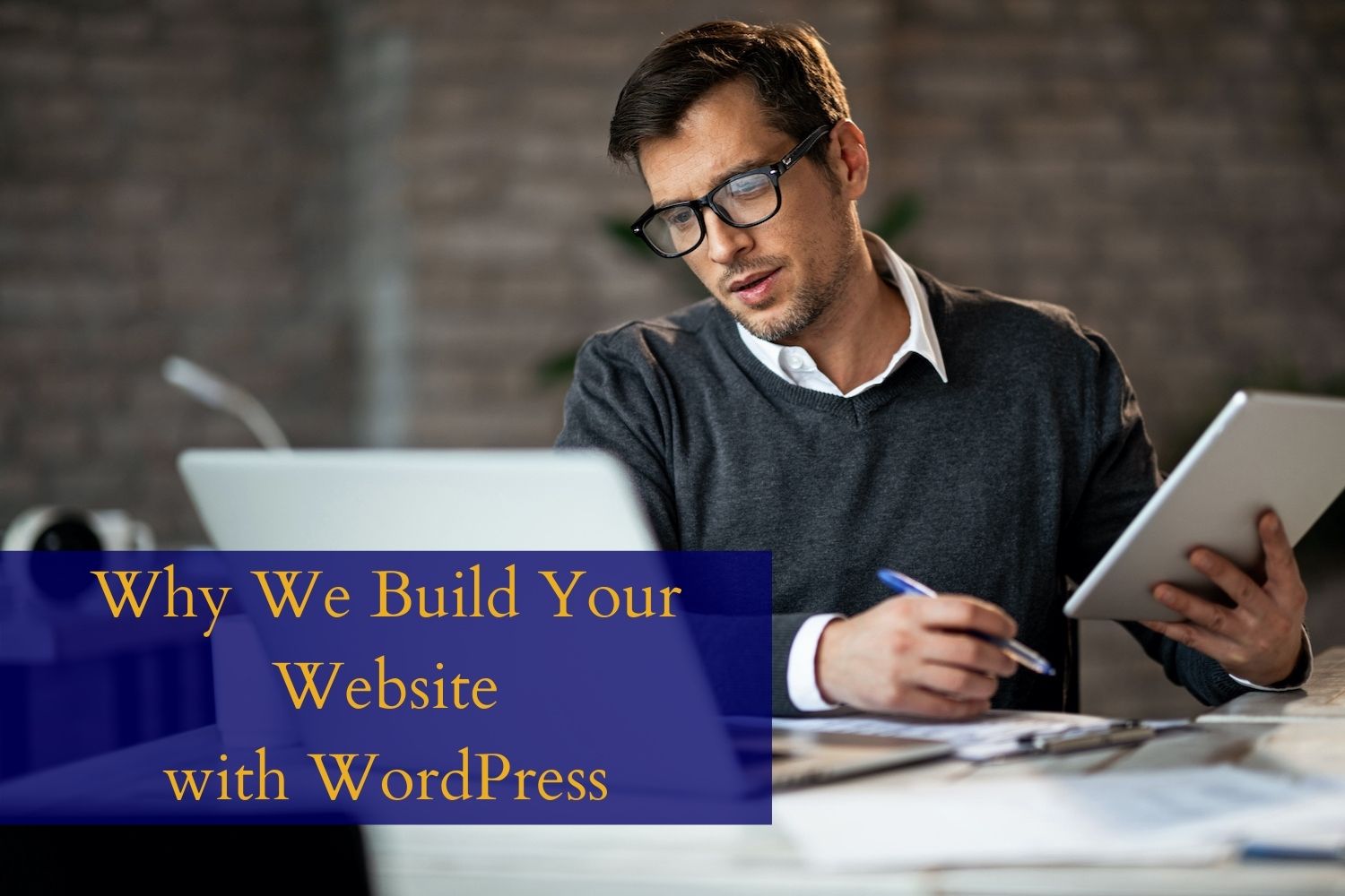 Man working at laptop computer, reading why we build your website with WordPress